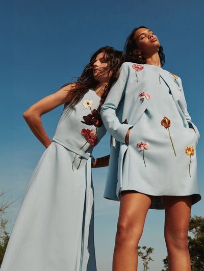 Two models pose in the sunshine wearing blue Oscar de la Renta ready-to-wear styles. 