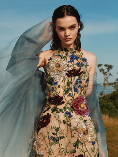 A model is seen posing outside in an Oscar de la Renta embroidered dress. 