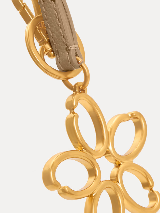 Gold O Flower Wristlet Key Chain with five open petals hangs from a sand leather loop strap, attached by a small gold ring and clasp. Zoom View.