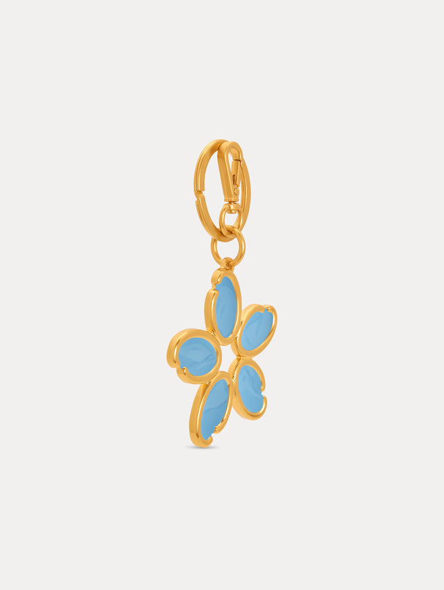 Gold Enamel O Flower Key Chain featuring a five-petal flower charm with smooth, light blue enamel inlays framed by rounded gold edges, attached to a circular clasp. Side View.