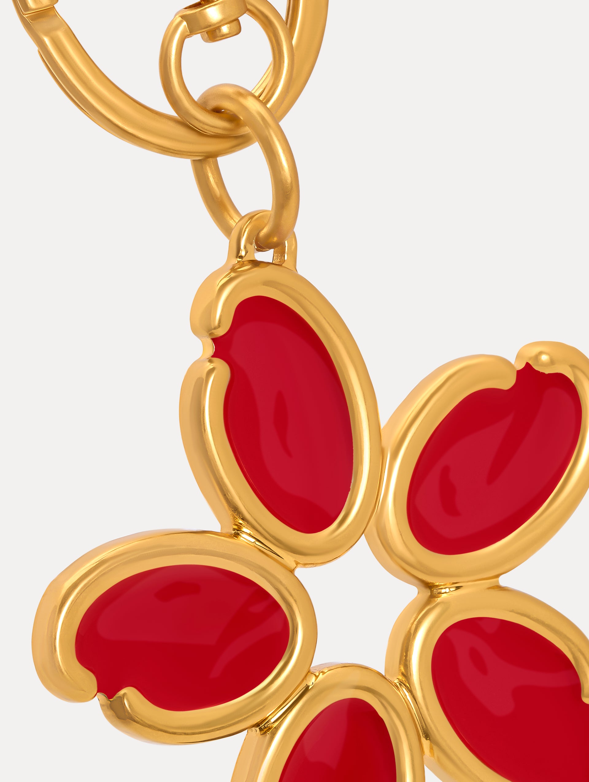 Gold Enamel O Flower Key Chain featuring a five-petal flower charm with smooth, red inlays framed by rounded gold edges, attached to a circular clasp. Zoom View.