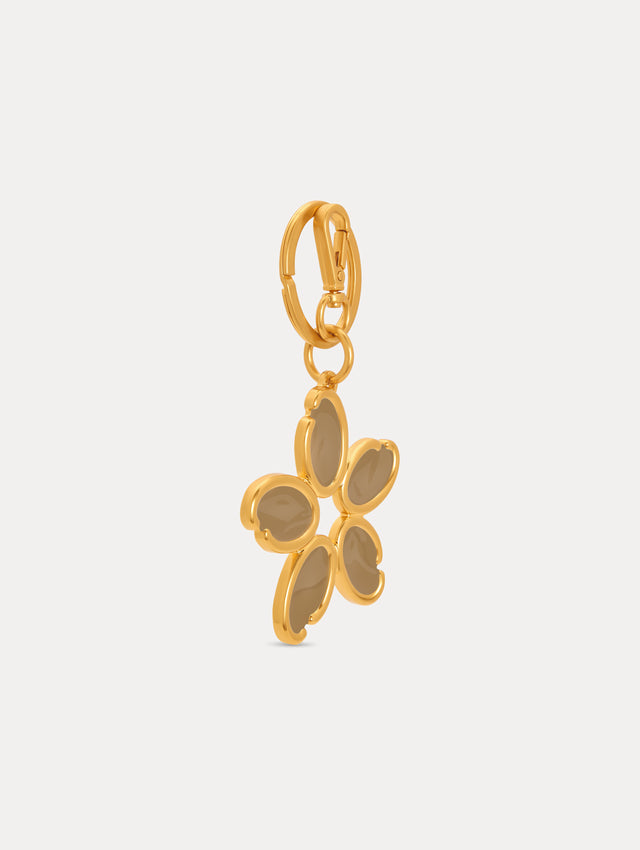 Gold Enamel O Flower Key Chain featuring a five-petal flower charm with smooth, taupe-colored inlays framed by rounded gold edges, attached to a circular clasp. Side View.