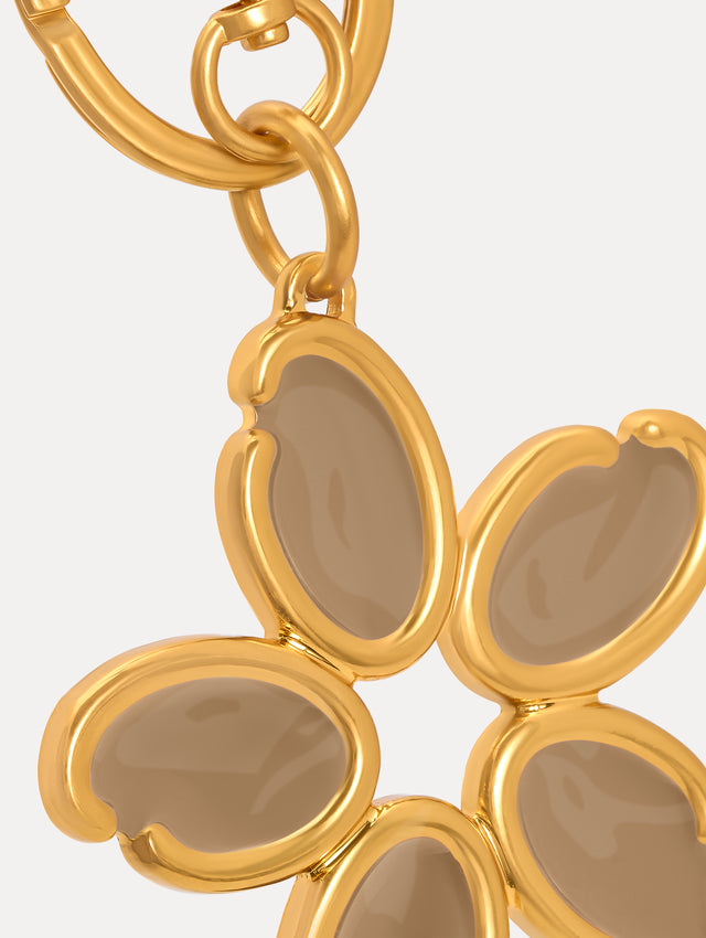 Gold Enamel O Flower Key Chain featuring a five-petal flower charm with smooth, taupe-colored inlays framed by rounded gold edges, attached to a circular clasp. Zoom View.