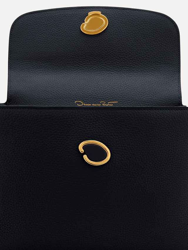 The Poppy leather bag in dark navy with O logo tag around the top handle. Zoom View