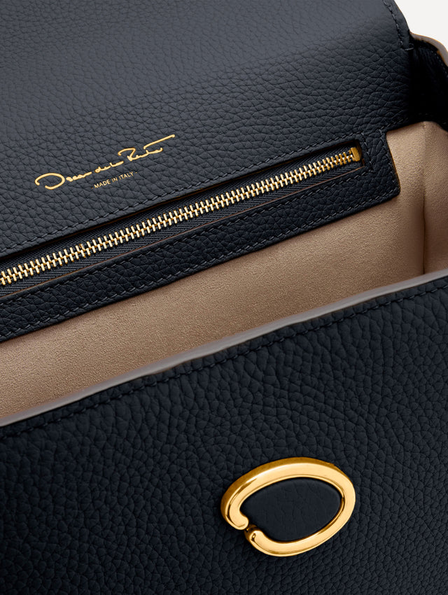 The Poppy leather bag in dark navy with O logo tag around the top handle. Zoom View