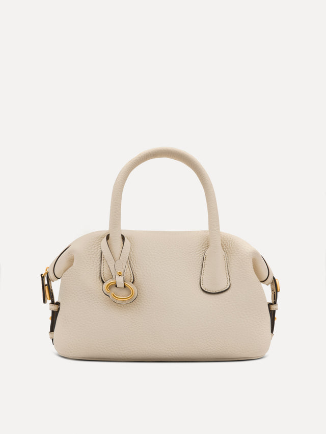 The Mini Dahlia leather handbag in ivory, with O logo tag around the top handle and a Gold Heart bag charm on the other side. Front View