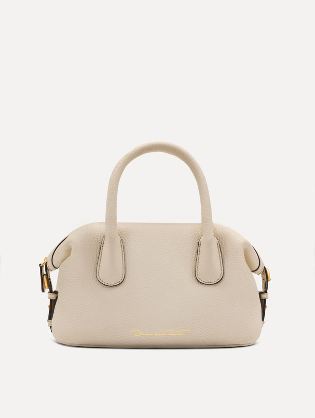 The Mini Dahlia leather handbag in ivory, with O logo tag around the top handle and a Gold Heart bag charm on the other side. Back View