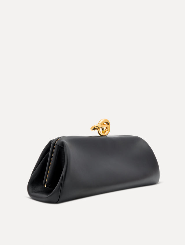 Side view of black clutch with gold 'O' emblem on the clasp. 