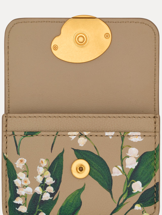 Beige Lily of the Valley–Printed Card Case with green and white floral motifs and a gold O motif clasp. Zoom View.