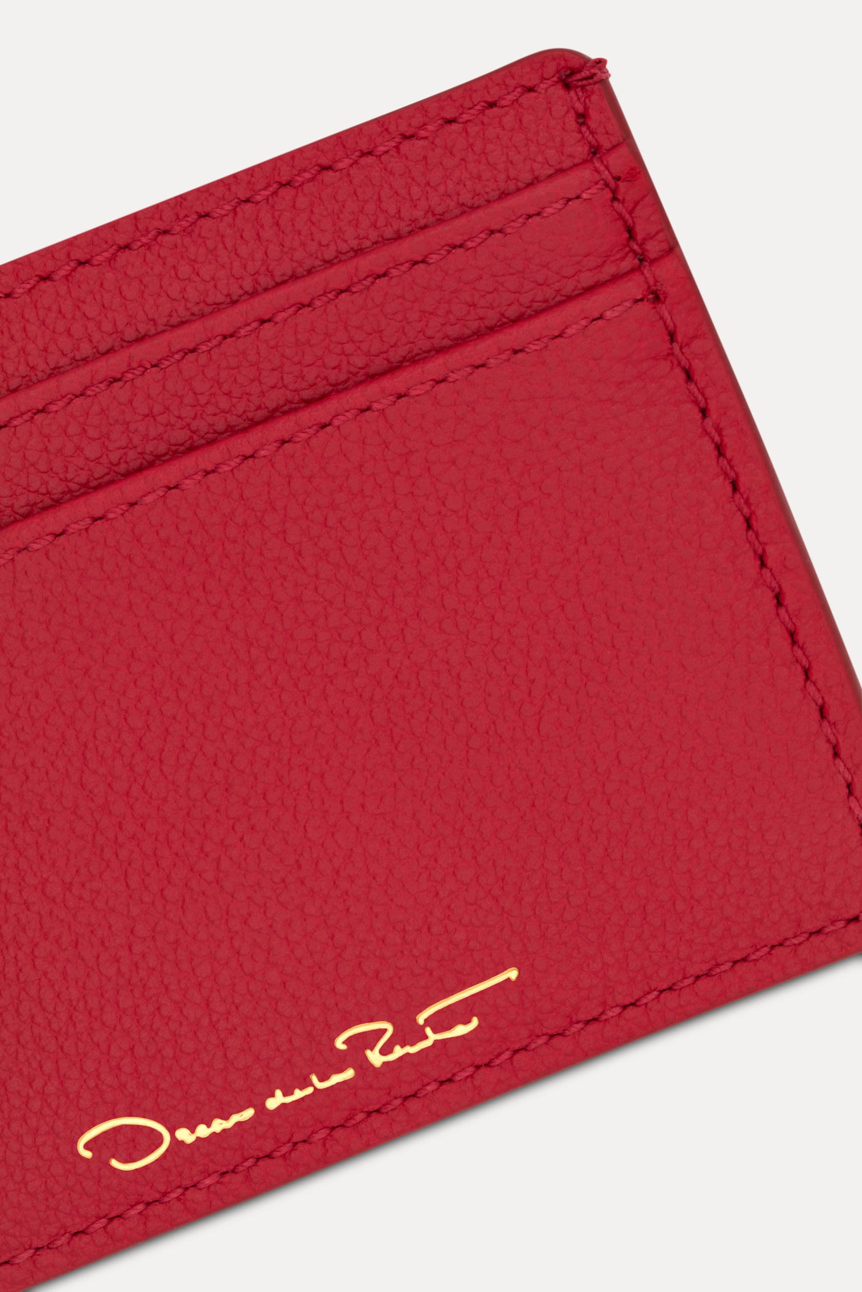 Red card case featuring gold printed Oscar de la Renta logo on back. Zoom View.