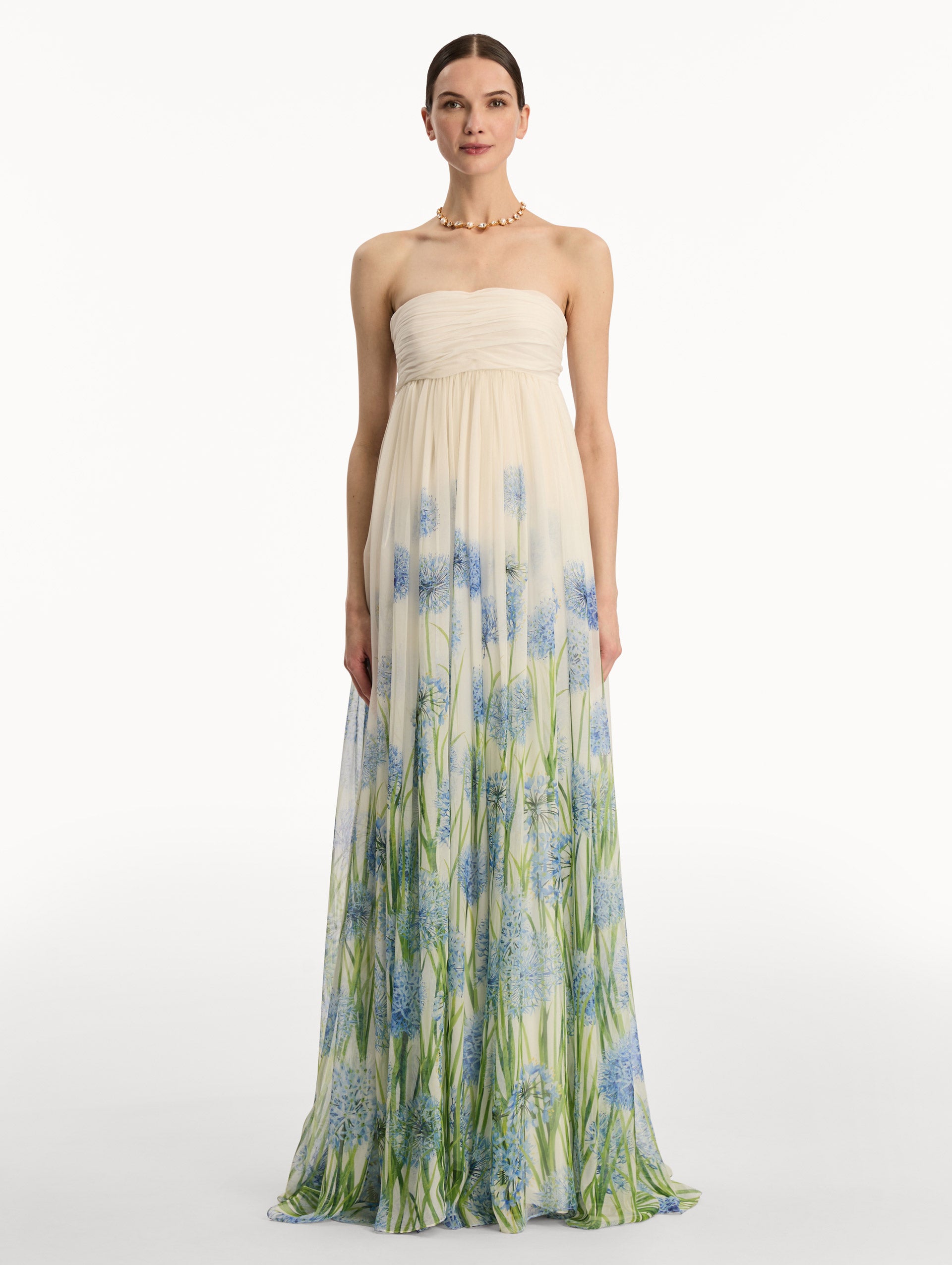 Ivory Degradé Allium Chiffon Gown featuring a ruched bodice and flowing pleated skirt with a blue allium floral gradient print. Front View.