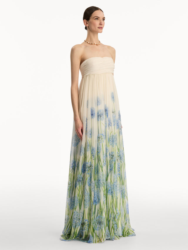 Ivory Degradé Allium Chiffon Gown featuring a ruched bodice and flowing pleated skirt with a blue allium floral gradient print. Side View.
