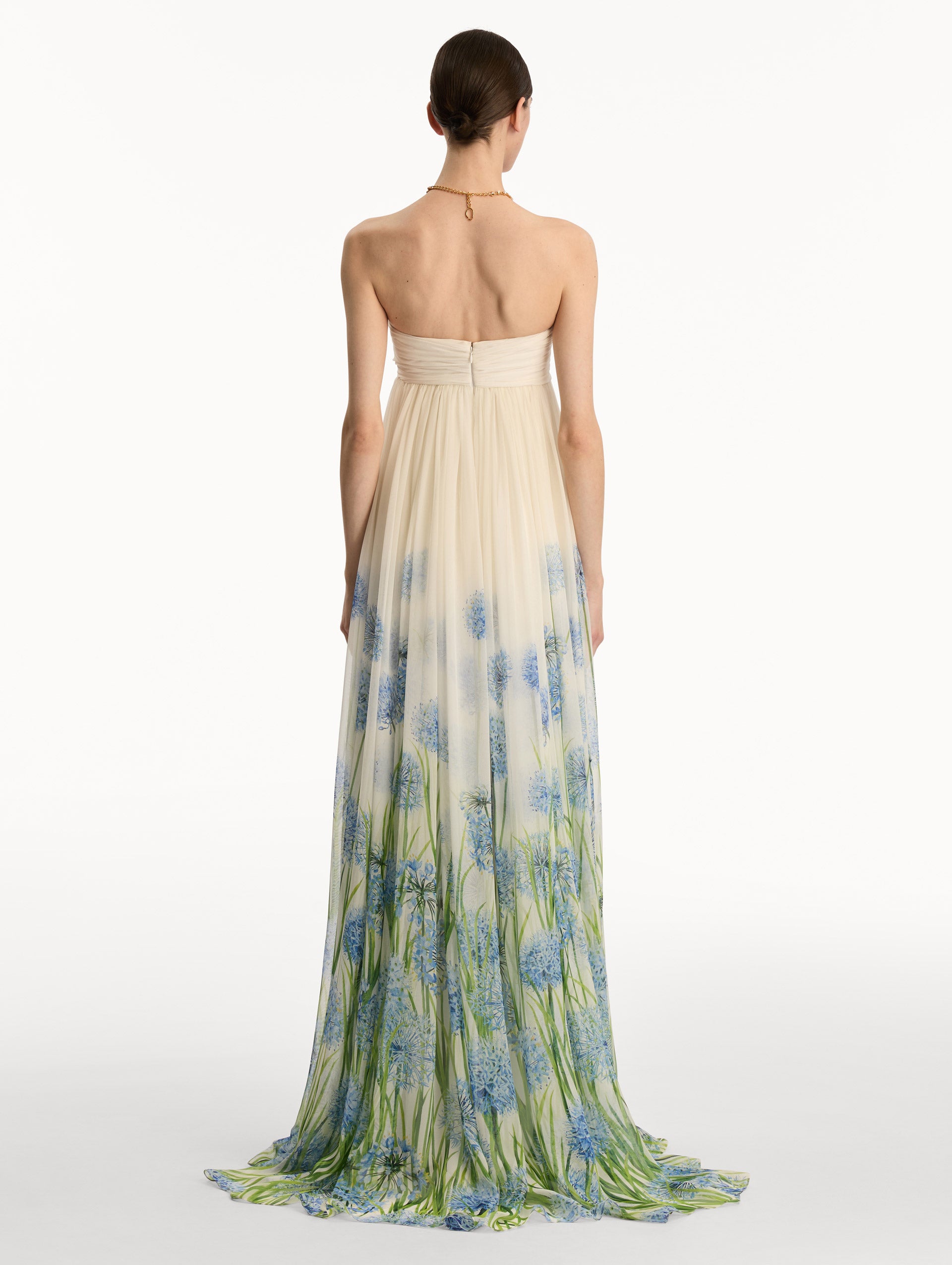 Ivory Degradé Allium Chiffon Gown featuring a ruched bodice and flowing pleated skirt with a blue allium floral gradient print. Back View.