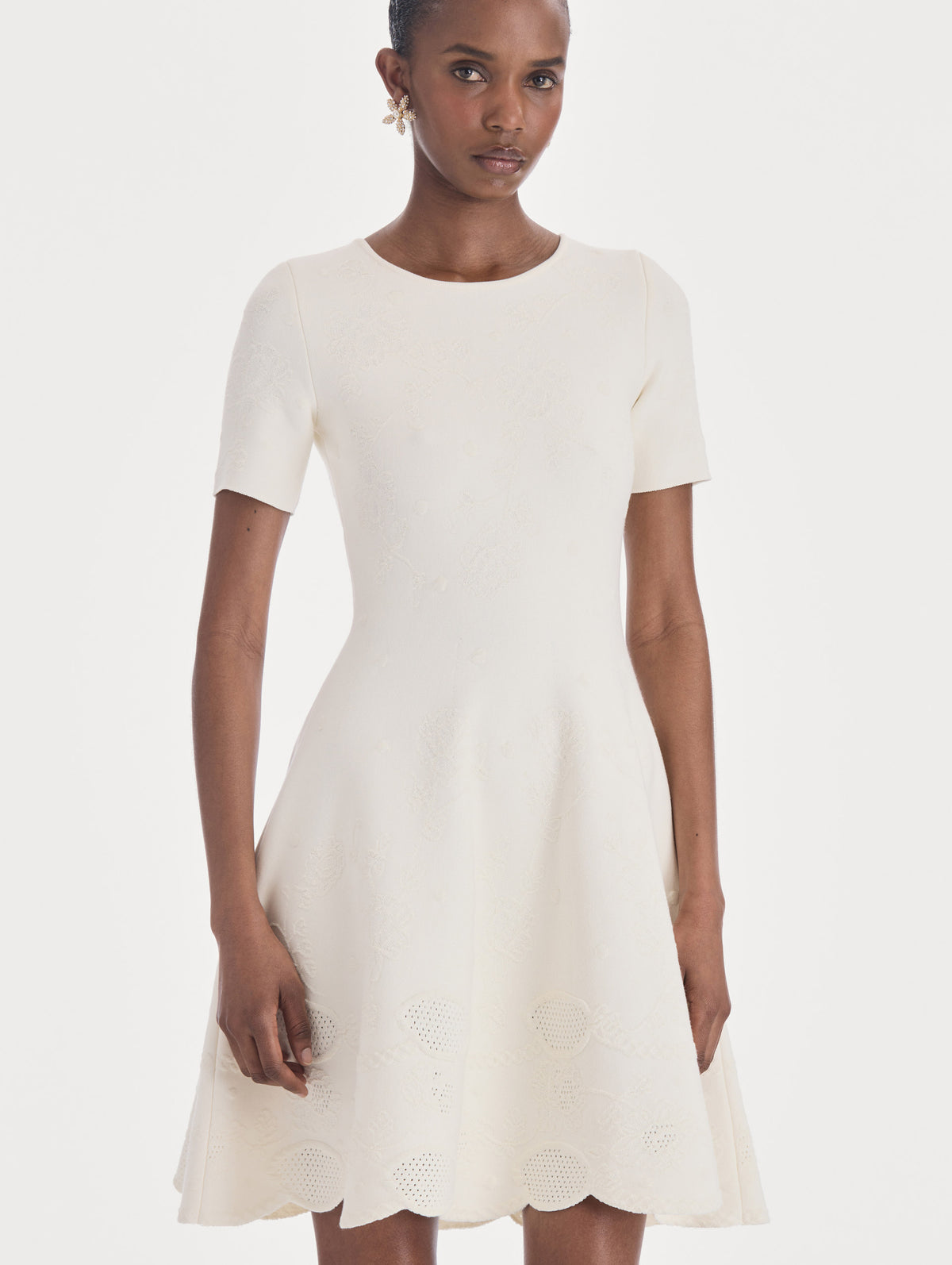 The model is wearing a fit and flare knit jacquard dress. Zoom view.