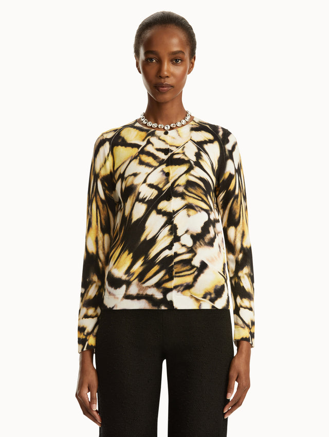 Abstract butterfly print in black, yellow, and white cardigan, paired with black pants. Front view