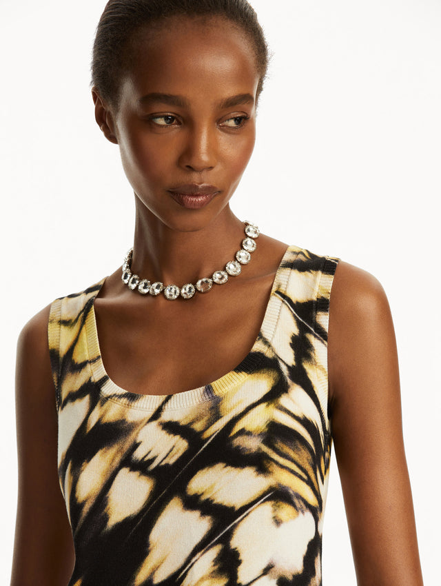 Model wearing Abstract butterfly print in yellow, black, and white tank, paired with black pants. Zoom view.
