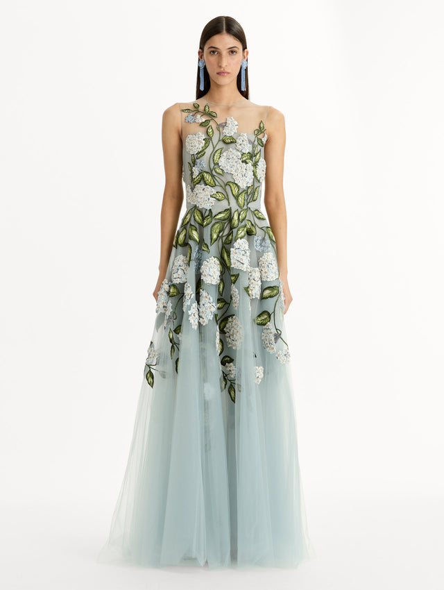 Sheer halter neck gown with porcelain flower embroidery blooming across blue illusion tulle skirt. Front View. 