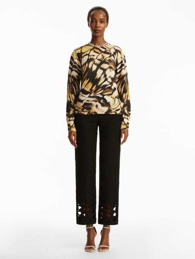 Abstract butterfly print in shades of black/brown, yellow, and white pullover, paired with black pants. front view