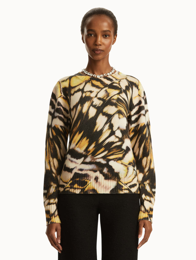 Abstract butterfly print in shades of black/brown, yellow, and white pullover, paired with black pants. front view