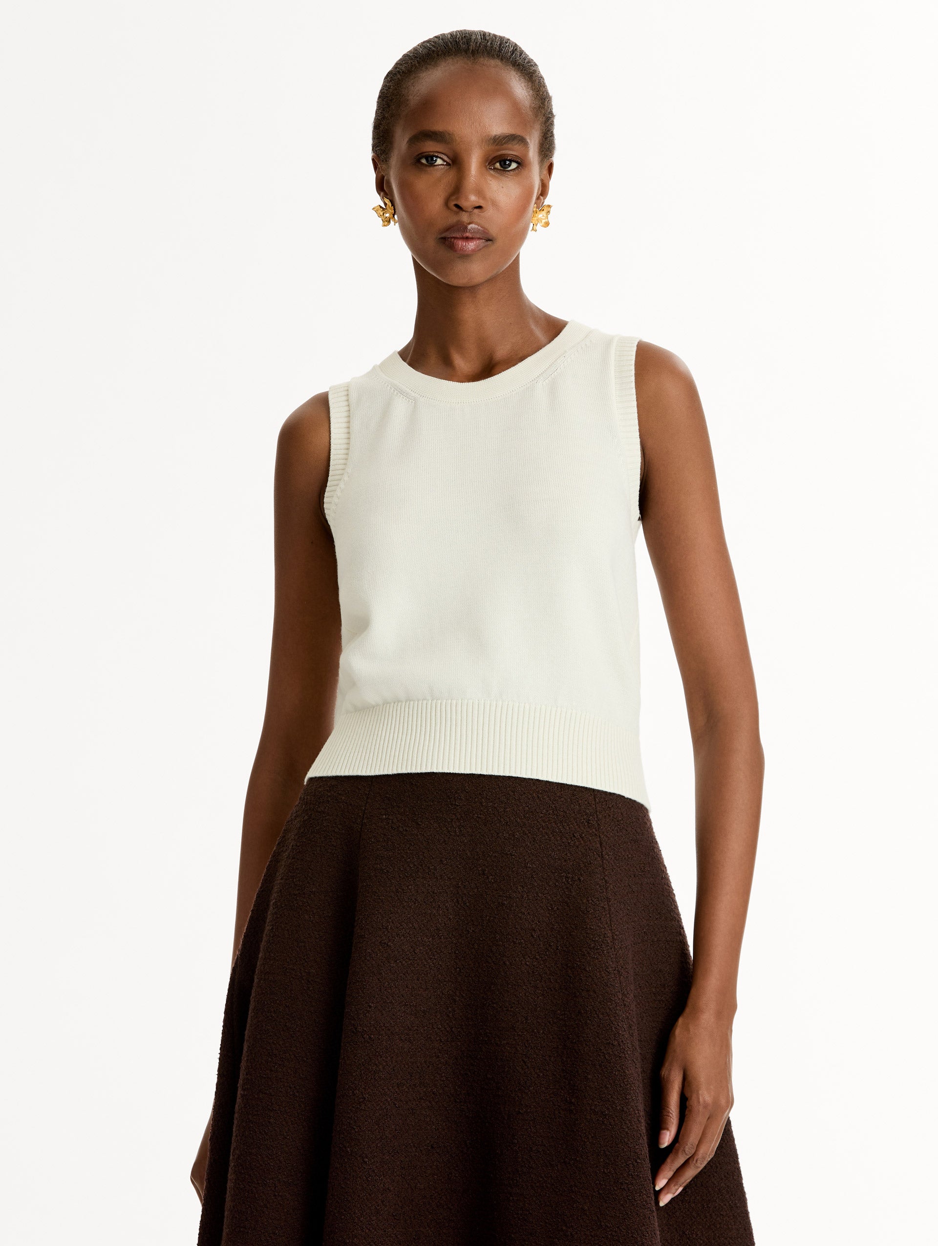 Sleeveless, halter neck, classic knit tank in soft ivory. Front View.