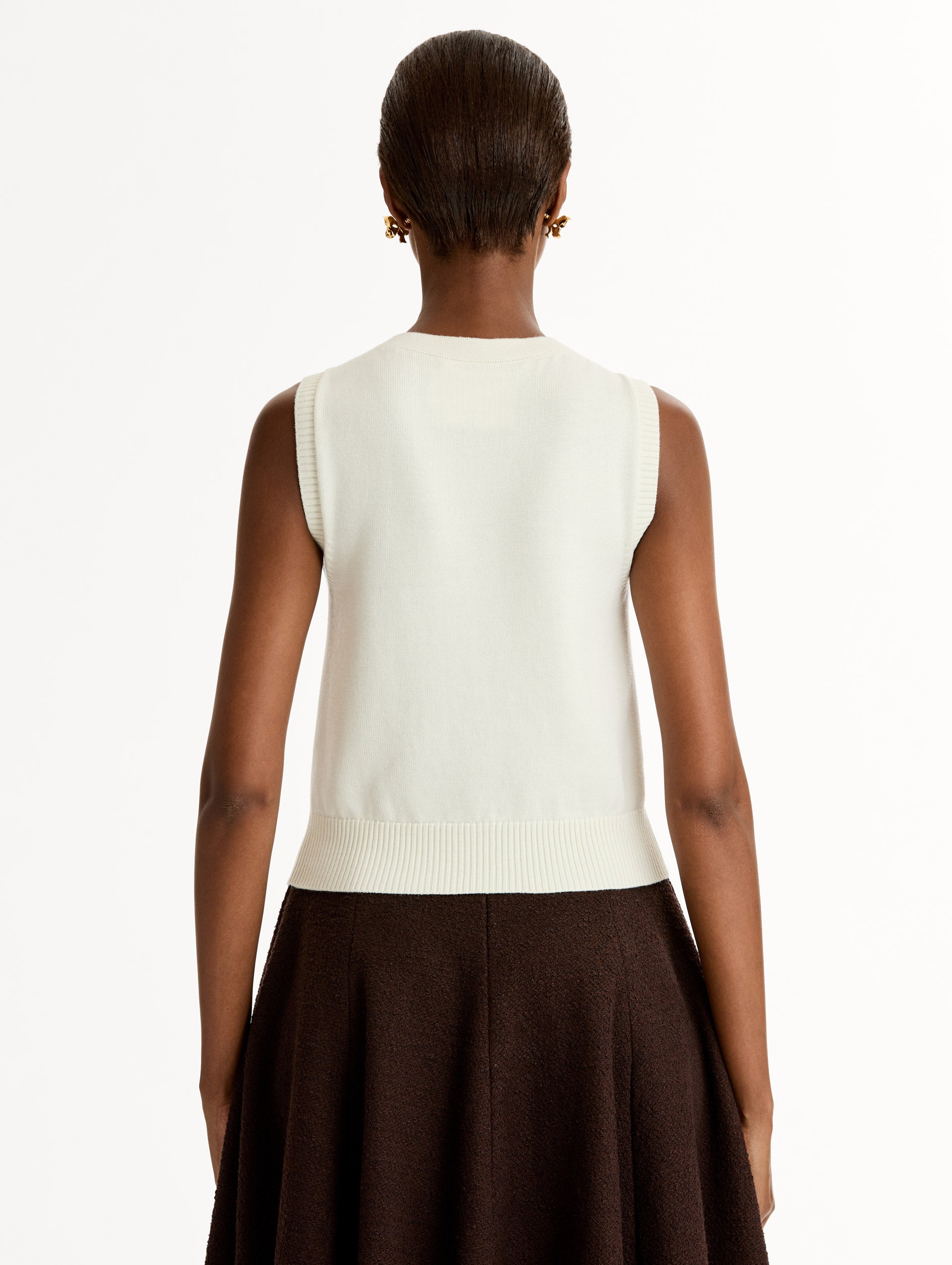 Sleeveless, halter neck, classic knit tank in soft ivory. Back View.
