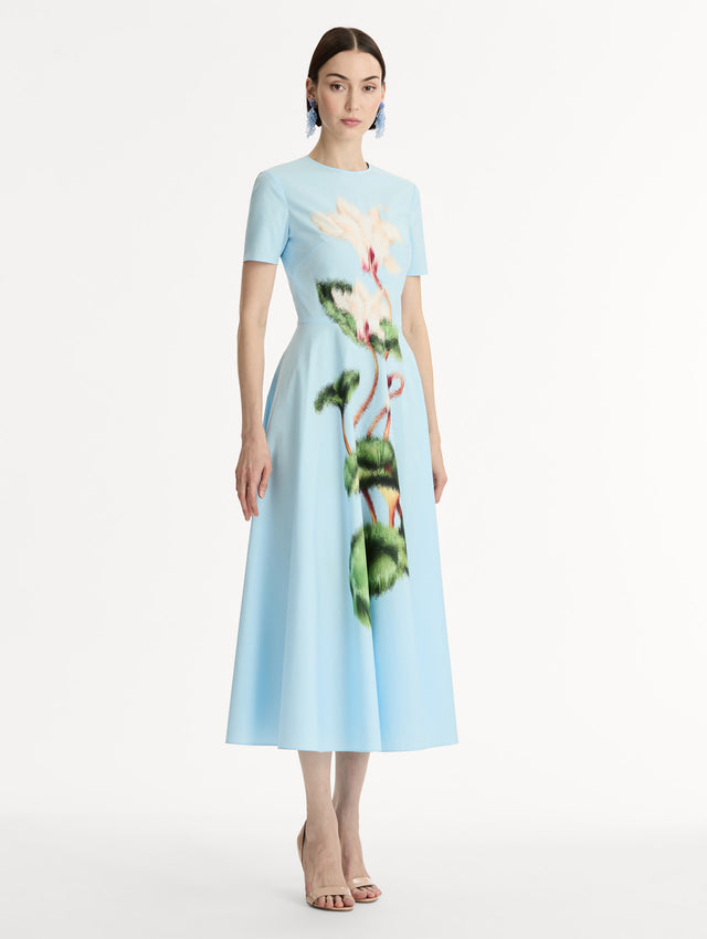 Short sleeve, light blue cotton poplin midi dress. Fitted bodice, full A-line skirt. Chiné Cyclamen motif with blurred, edges. Side View.