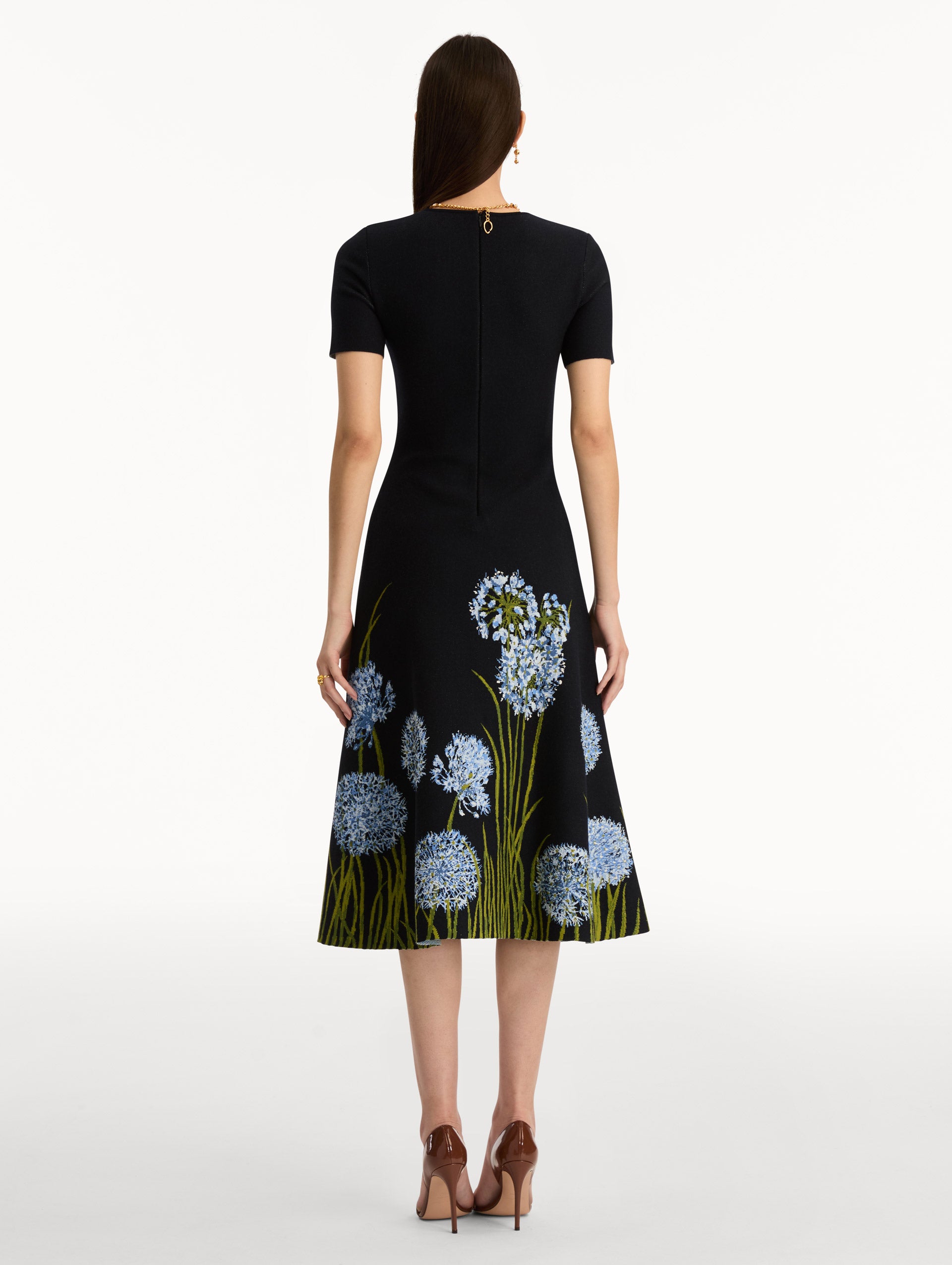 Navy Allium Jacquard Knit Dress featuring blue floral embroidery with green stem detailing along the skirt. Back View.