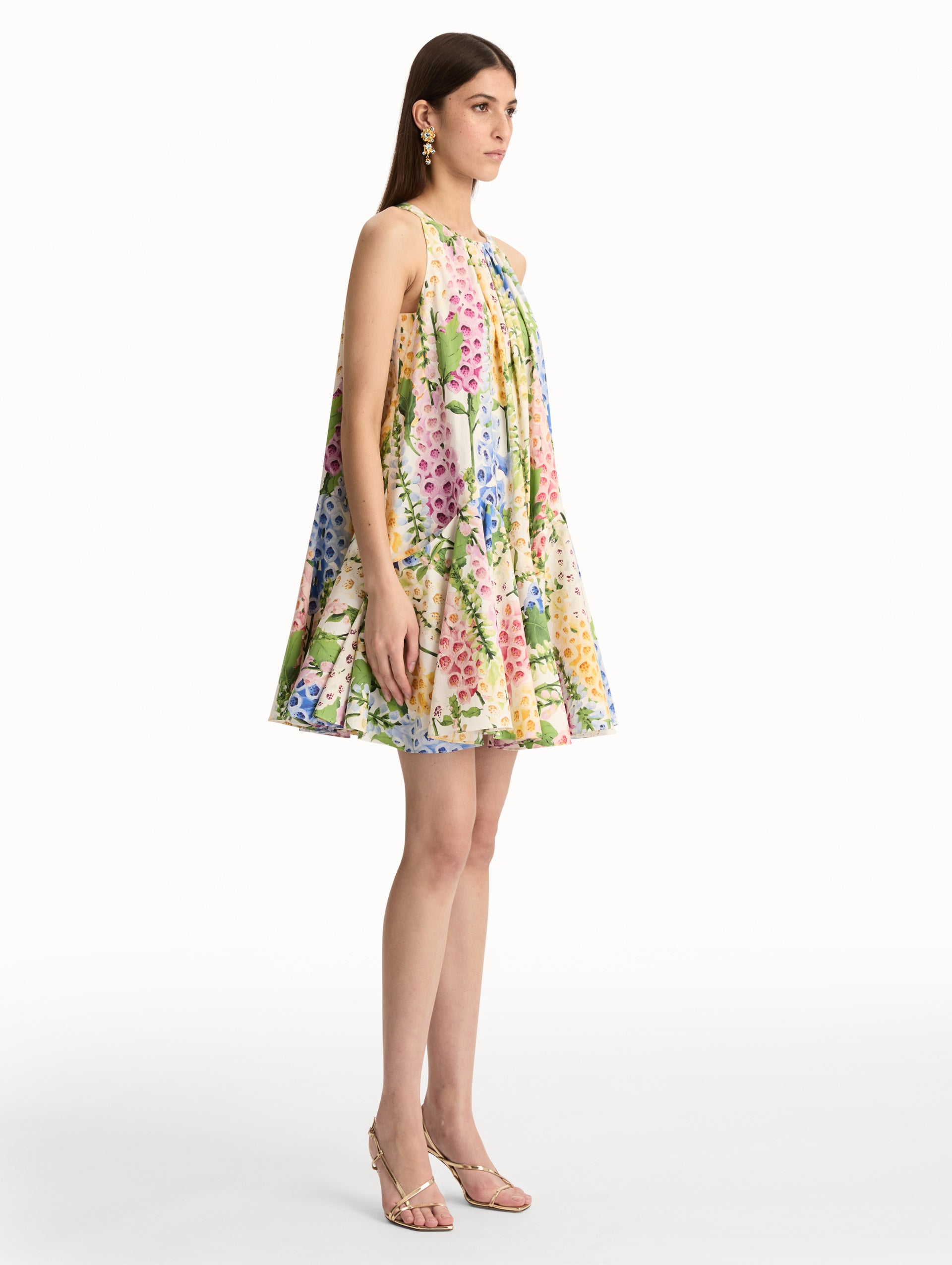 White and Floral Foxglove Cotton Poplin Trapeze Dress with a flowing pleated silhouette and round neckline. Side View.
