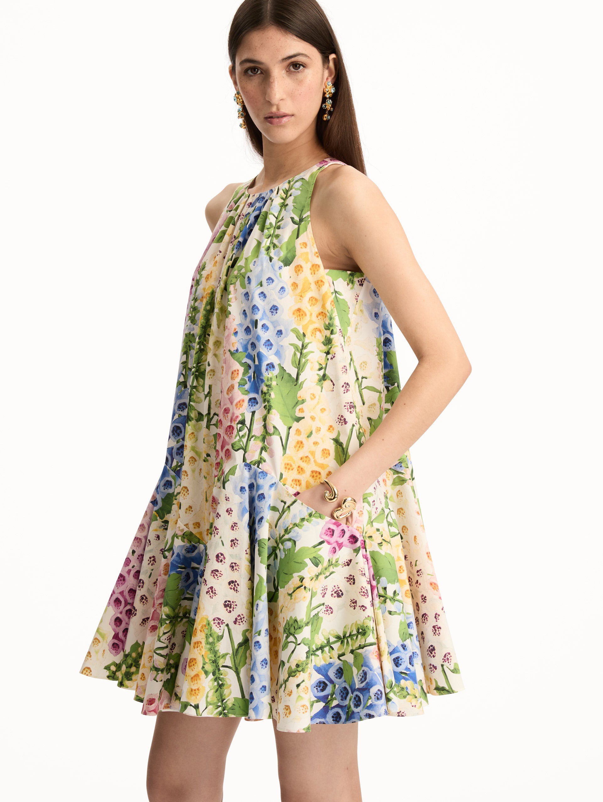 White and Floral Foxglove Cotton Poplin Trapeze Dress with a flowing pleated silhouette and round neckline. Zoom View.