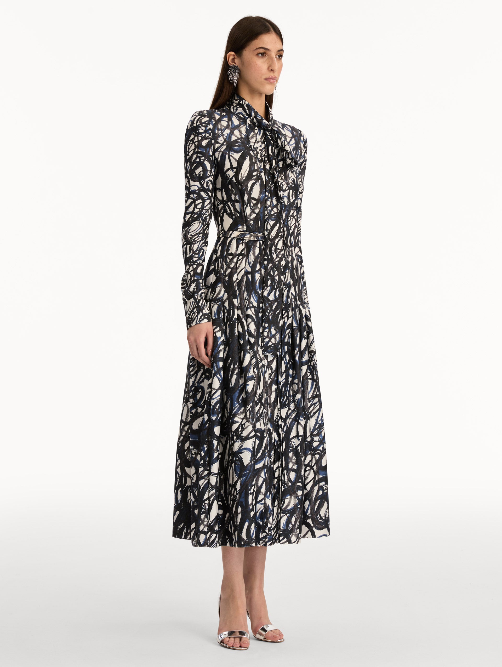 Ivory and Navy Abstract Sketch Silk Twill Dress with a belted waist and tie neck. Side View.