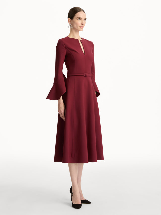 Wine colored Split Neck Wool Dress with belted waist and flowing bell sleeves. Side View.