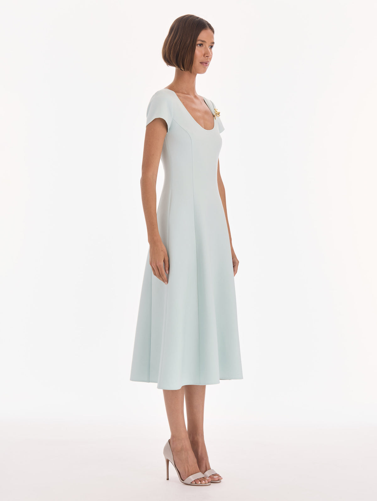 The model is wearing a short sleeve scoop neck stretch wool day dress. Side view.