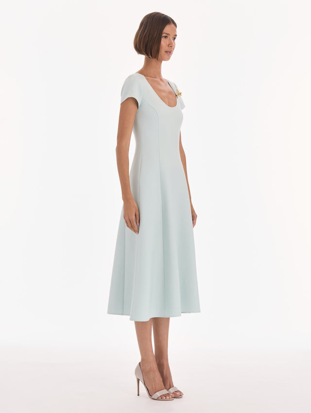 The model is wearing a short sleeve scoop neck stretch wool day dress. Side view.