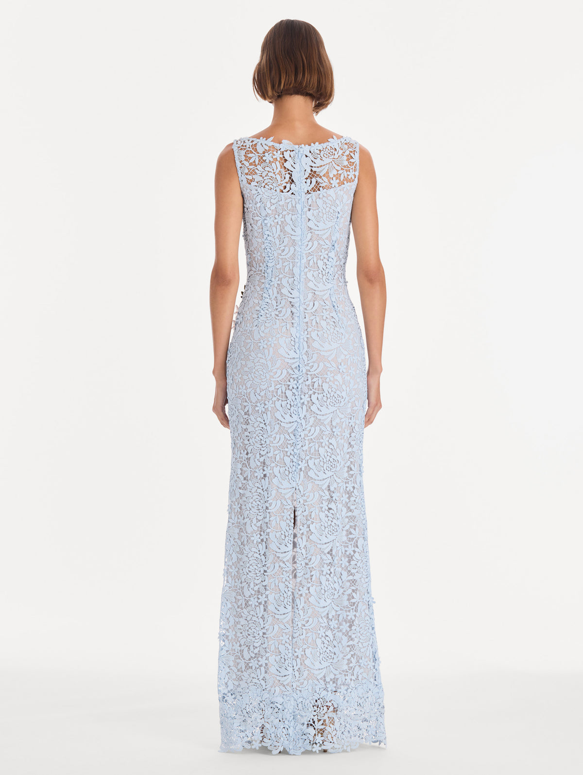 The model is wearing a sleeveless chrysanthemum guipure embroidered gown. Back view.