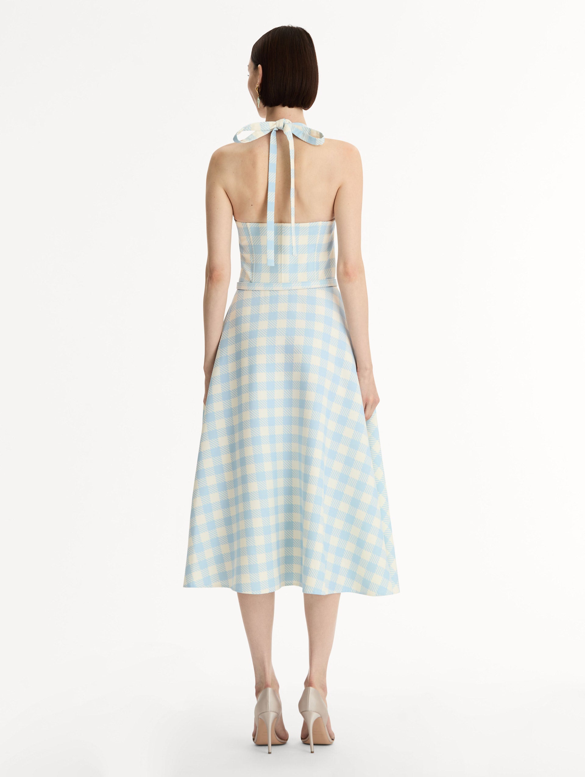 Pale blue and ivory gingham wool-blend halter dress. Structured bodice, flared midi skirt, and covered belt at the waist. Back View.
