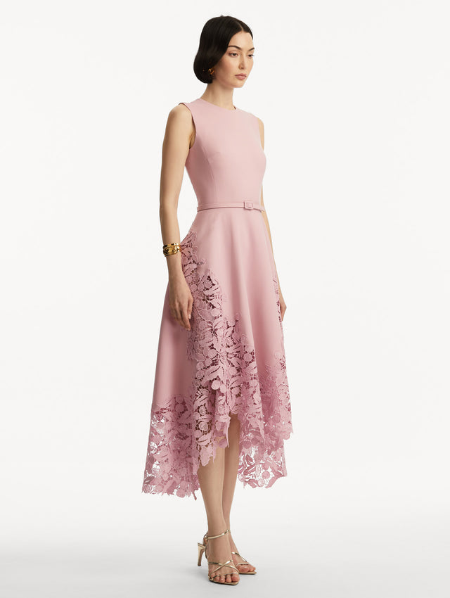 Sleeveless light pink dress with lace detail in the bottom and pink belt around the waist. Side view