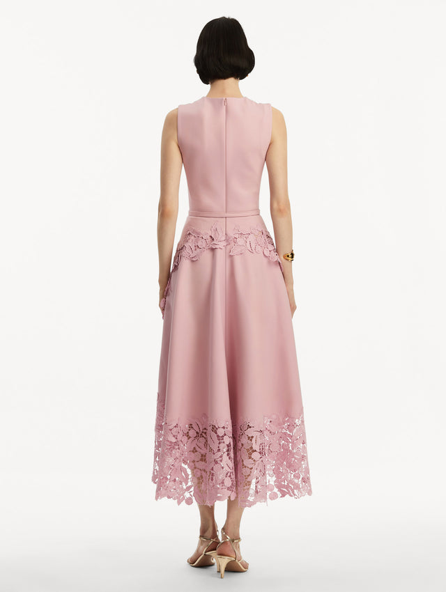 Sleeveless light pink dress with lace detail in the bottom and pink belt around the waist. Back view