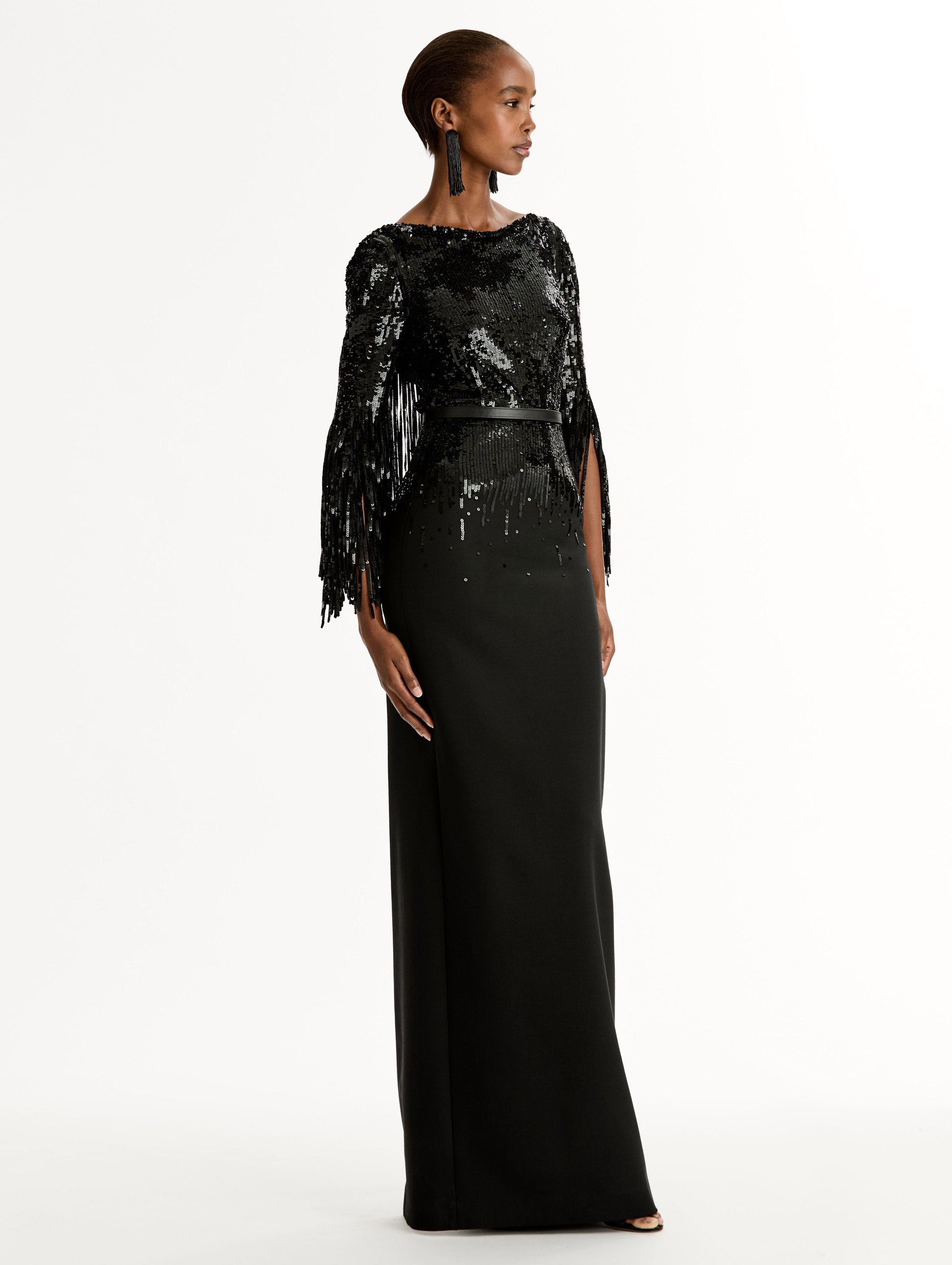 Black Sequin, Floor length gown in double-faced stretch wool. Open sleeves with beaded fringe. Side View.