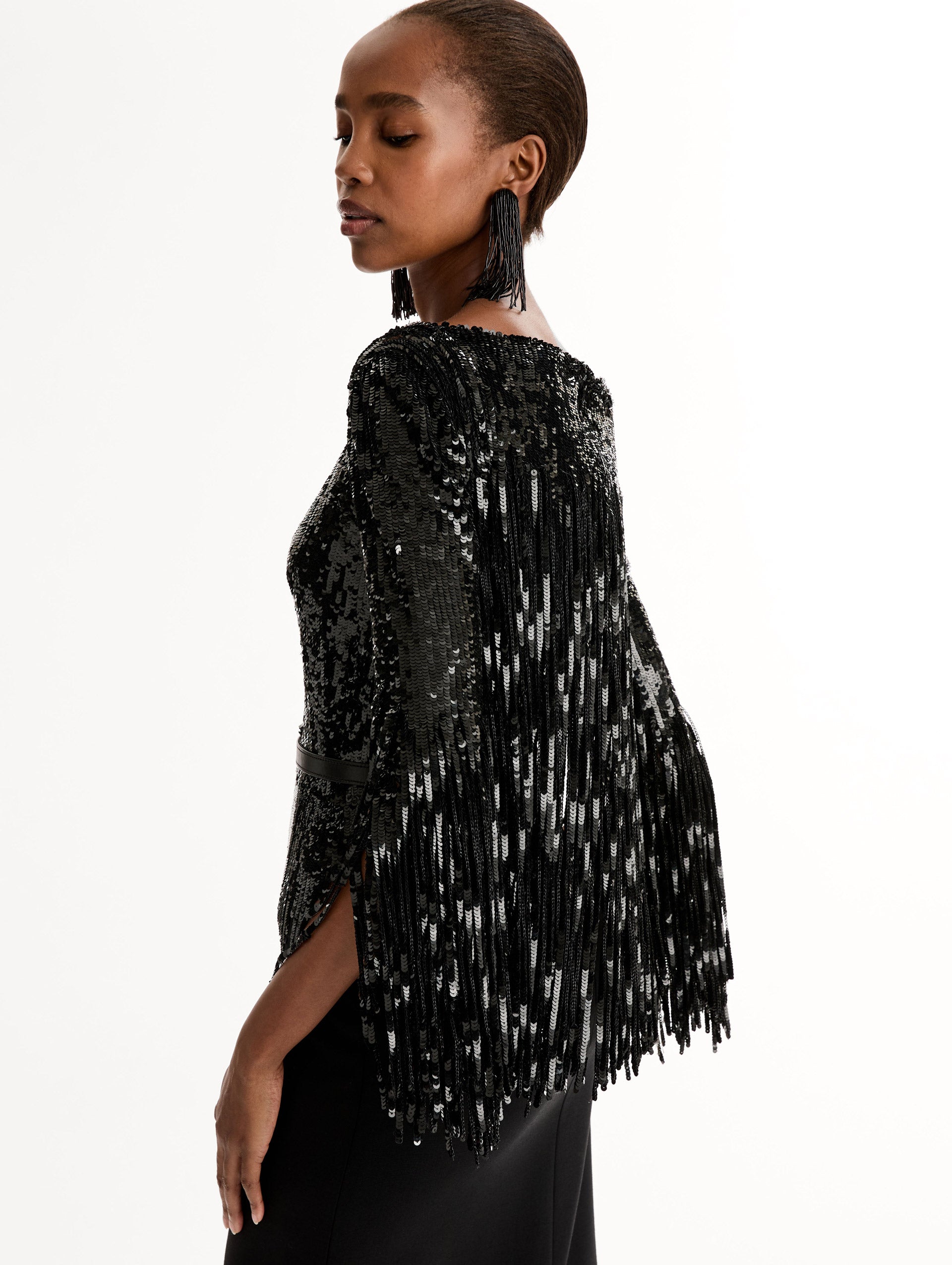 Black Sequin, Floor length gown in double-faced stretch wool. Open sleeves with beaded fringe. Side View, Close Up.