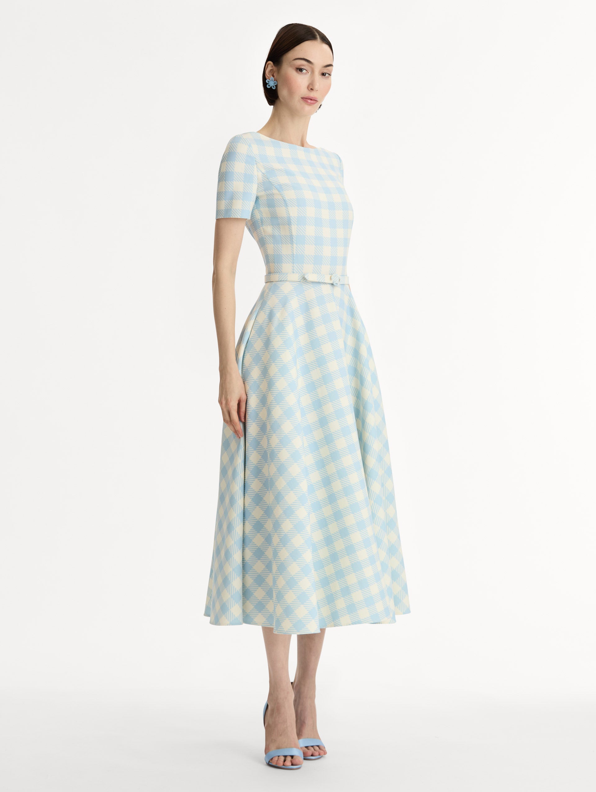 Pale blue and ivory gingham wool-blend midi dress. Fitted bodice, short sleeves, ull skirt, finished with a covered belt at the waist. Pocketed.  Side View.