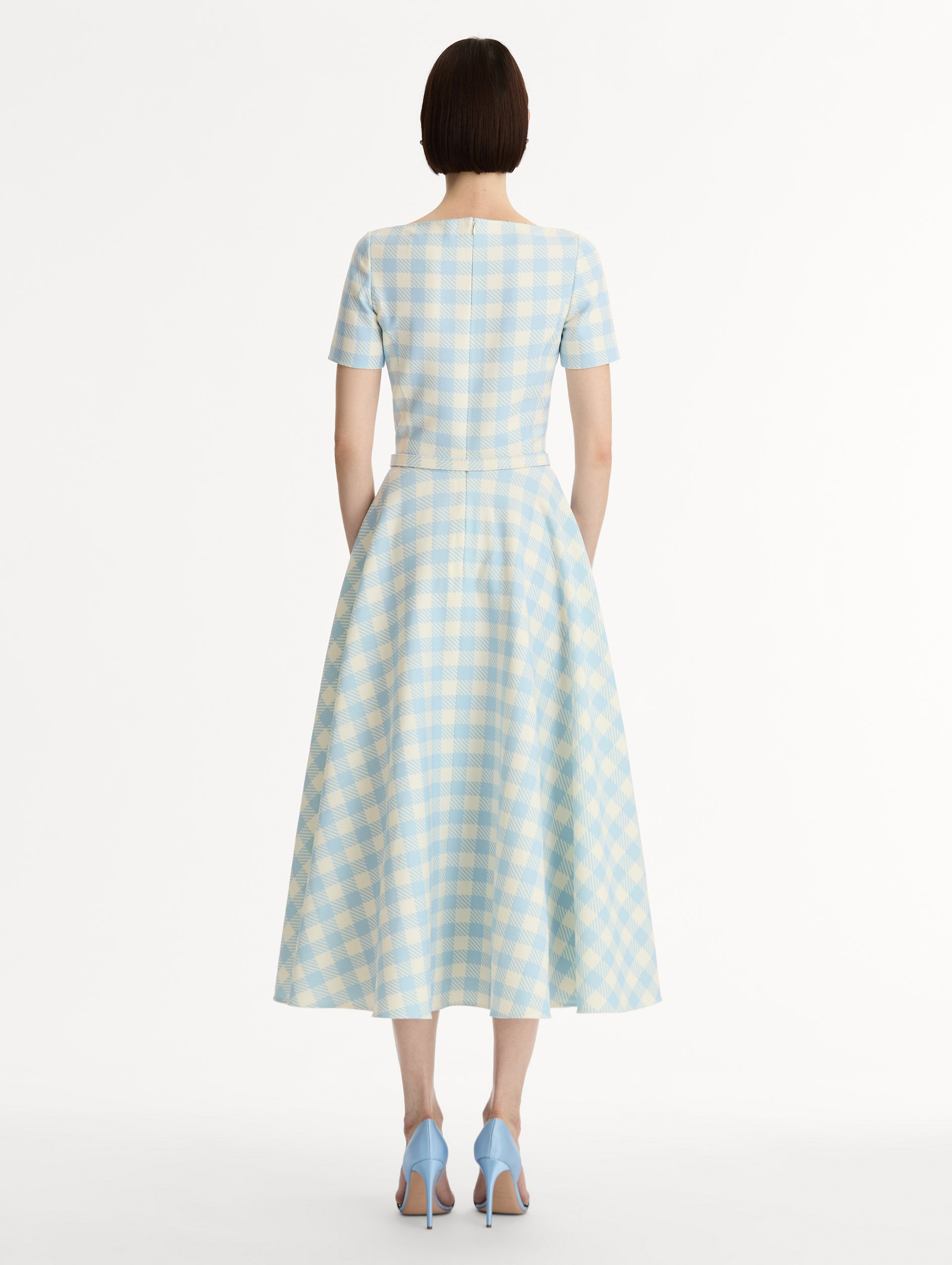 Pale blue and ivory gingham wool-blend midi dress. Fitted bodice, short sleeves, ull skirt, finished with a covered belt at the waist. Pocketed. Back View.