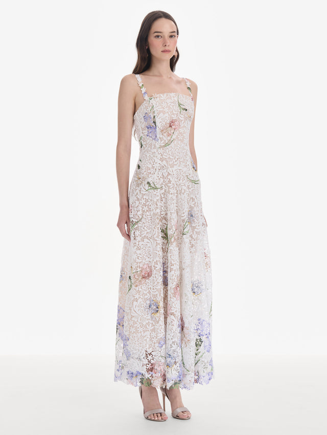 The model is wearing a sleeveless large iris degrade printed lace day dress. Side view.
