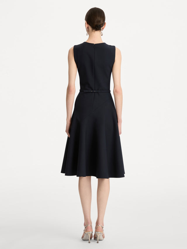 Black Floral Belt Sleeveless Dress featuring a belted waist with a white floral embellishment and a knee-length skirt. Back View.