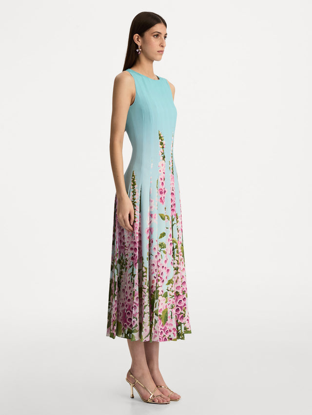 Blue Degradé Foxglove Chiffon Inset Dress featuring vertical pleats and a multicolor pink floral motif rising from the hem. Side View.