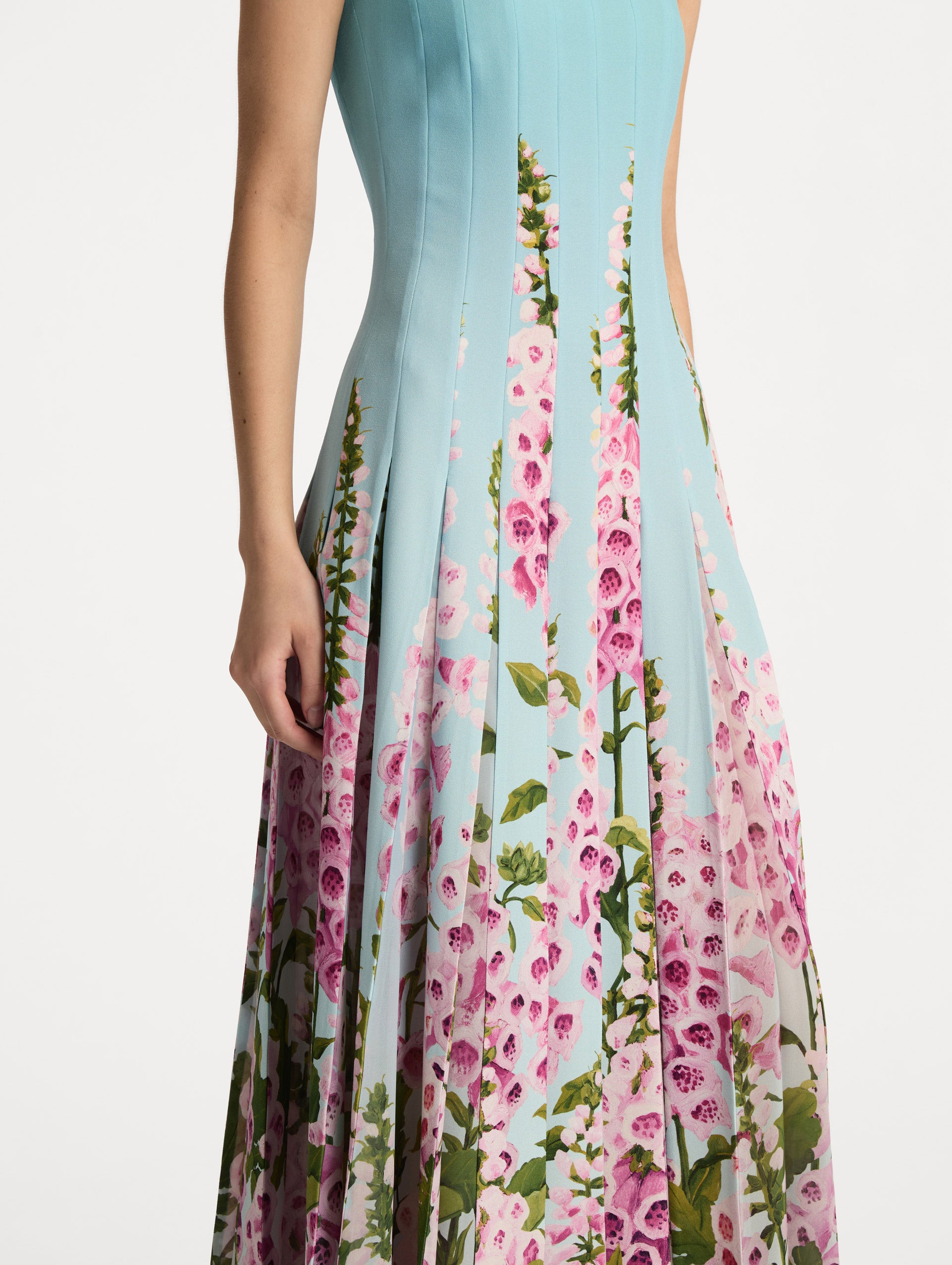 Blue Degradé Foxglove Chiffon Inset Dress featuring vertical pleats and a multicolor pink floral motif rising from the hem. Zoom View.