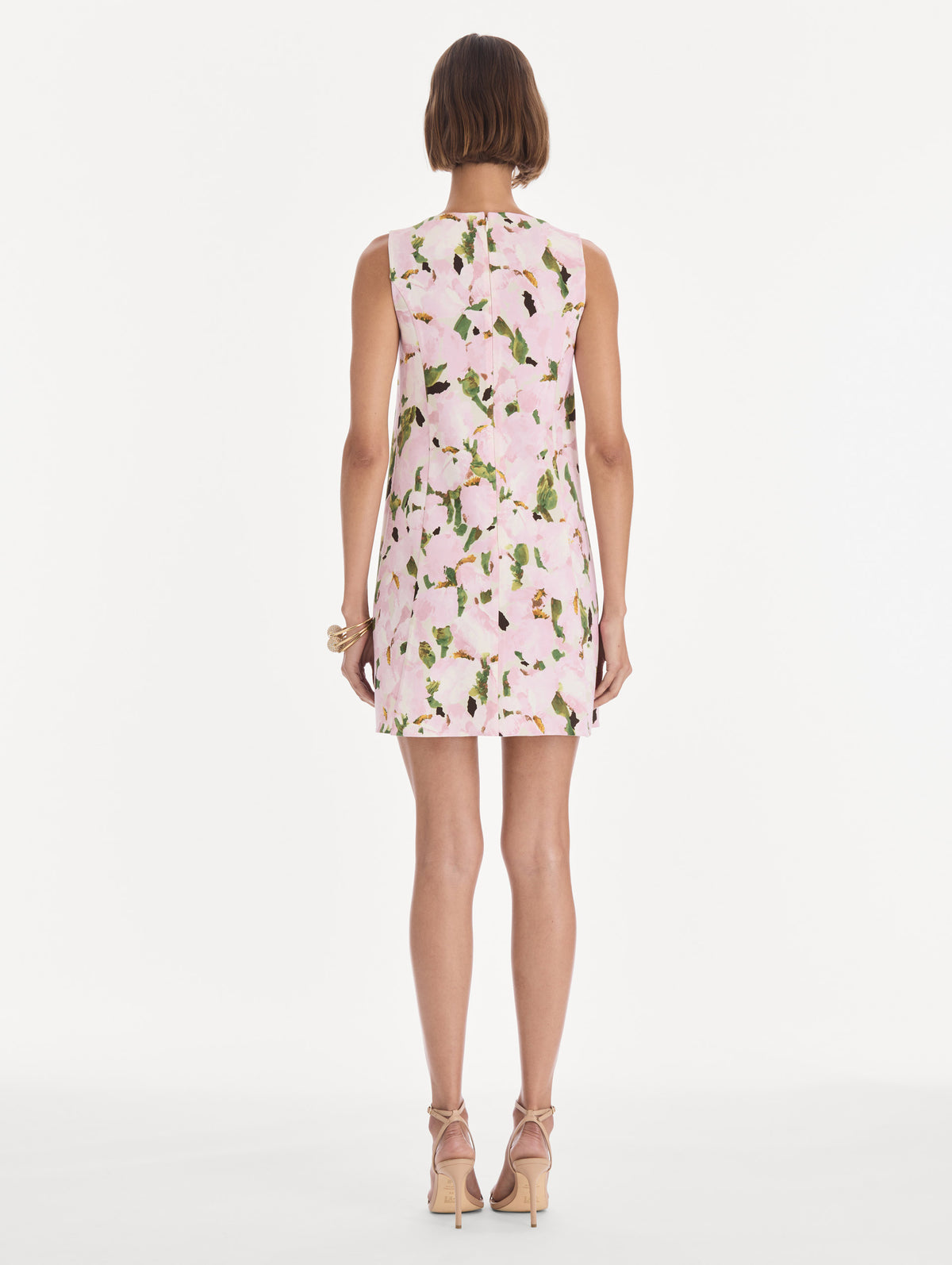 The model is wearing a sleeveless watercolor iris wool shift dress. Back view.