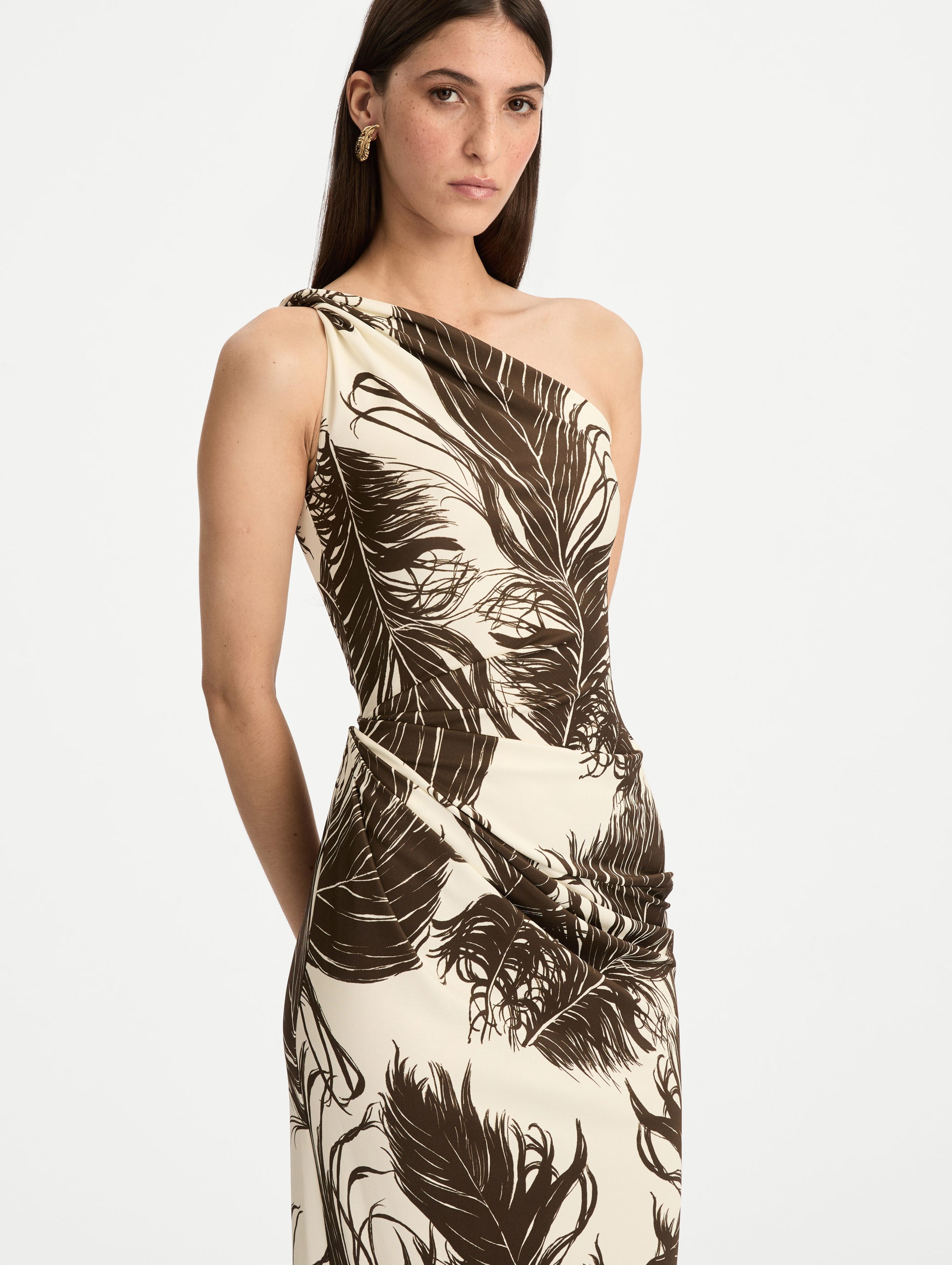 Ivory and Black Feather Jersey Maxi Dress with a one shoulder slim silhouette, featuring bold black feather print detailing. Zoom View.
