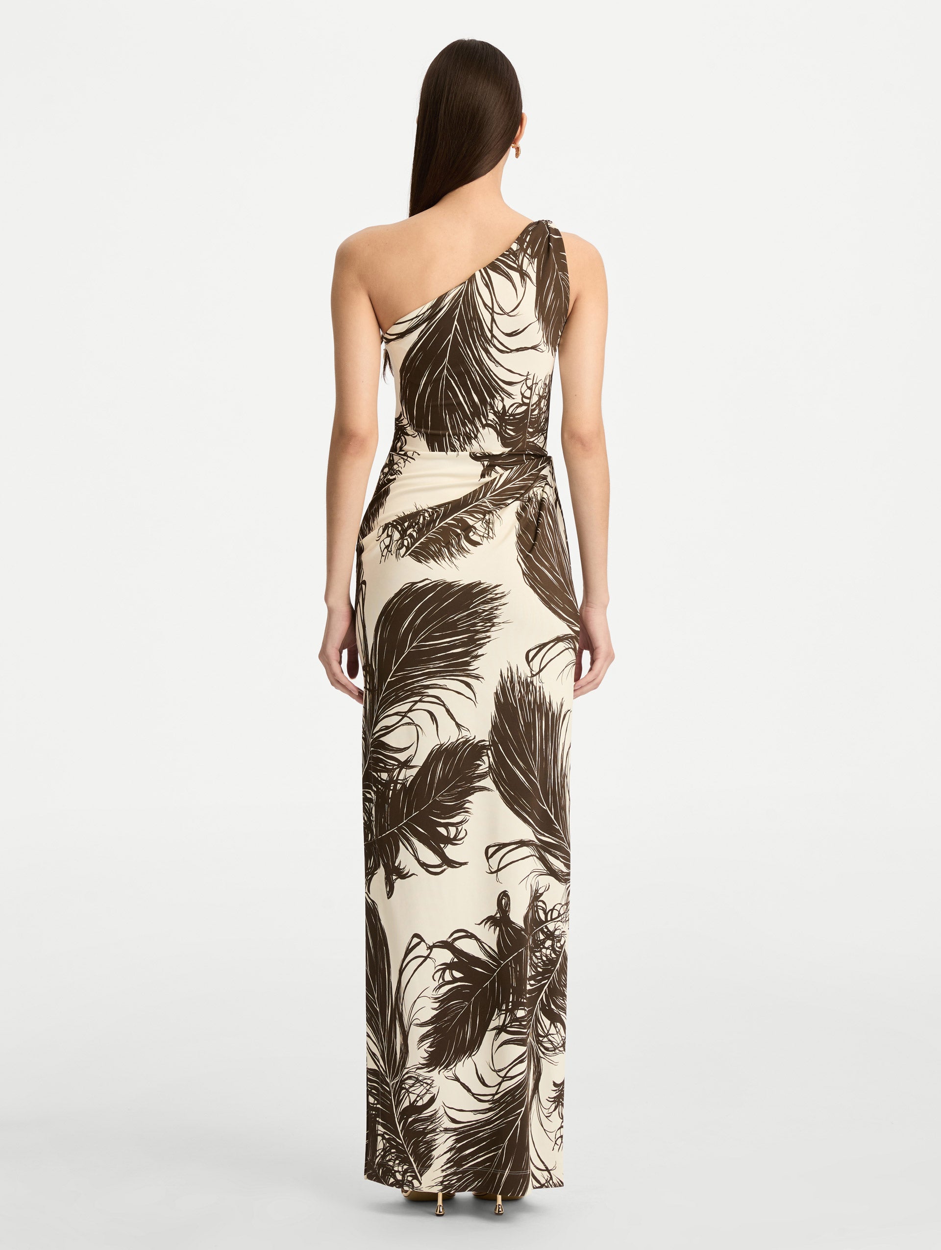 Ivory and Black Feather Jersey Maxi Dress with a one shoulder slim silhouette, featuring bold black feather print detailing. Back View.