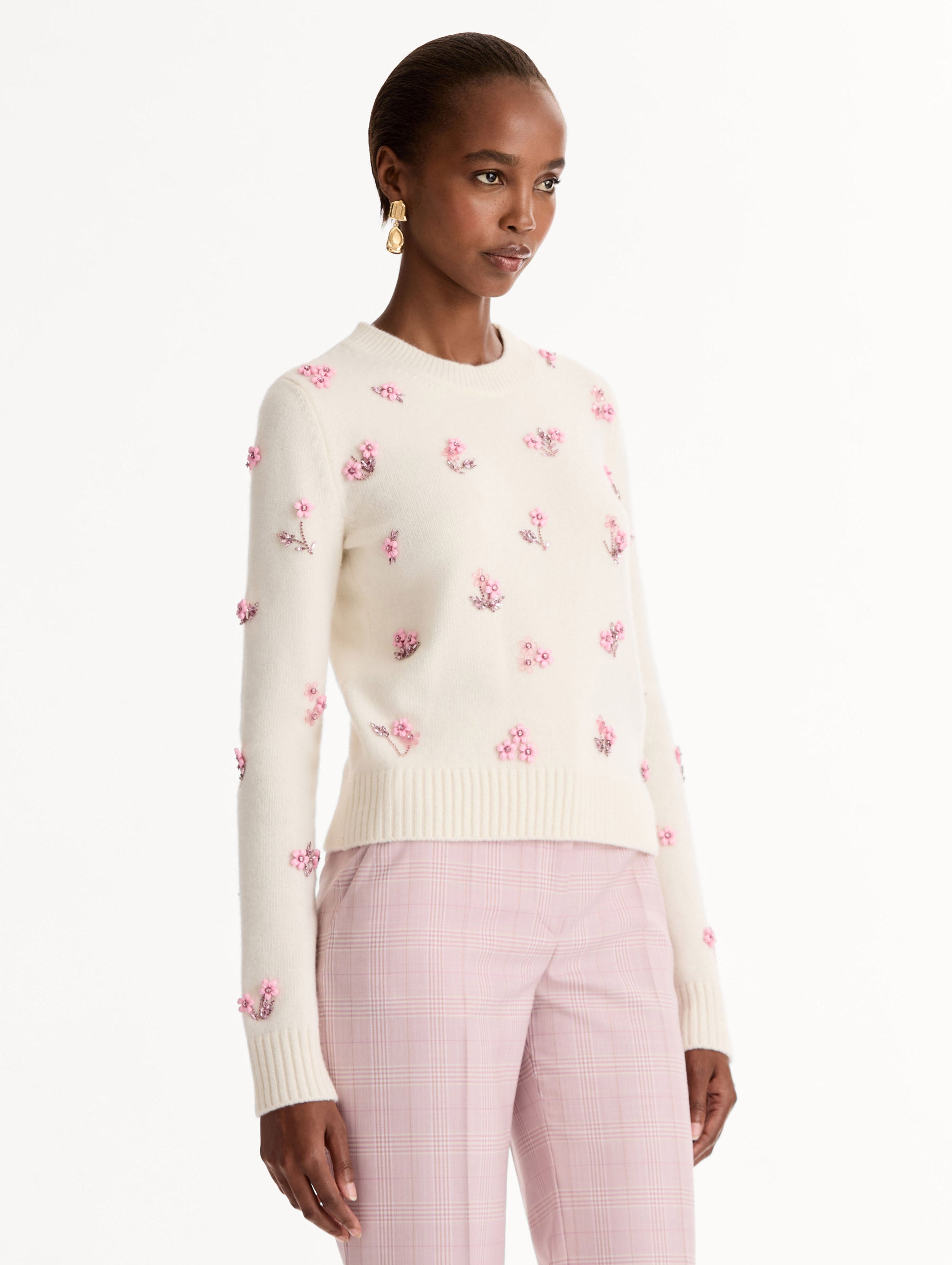 Crew neck, long sleeve sweater with pink floral embellishments. Side View.