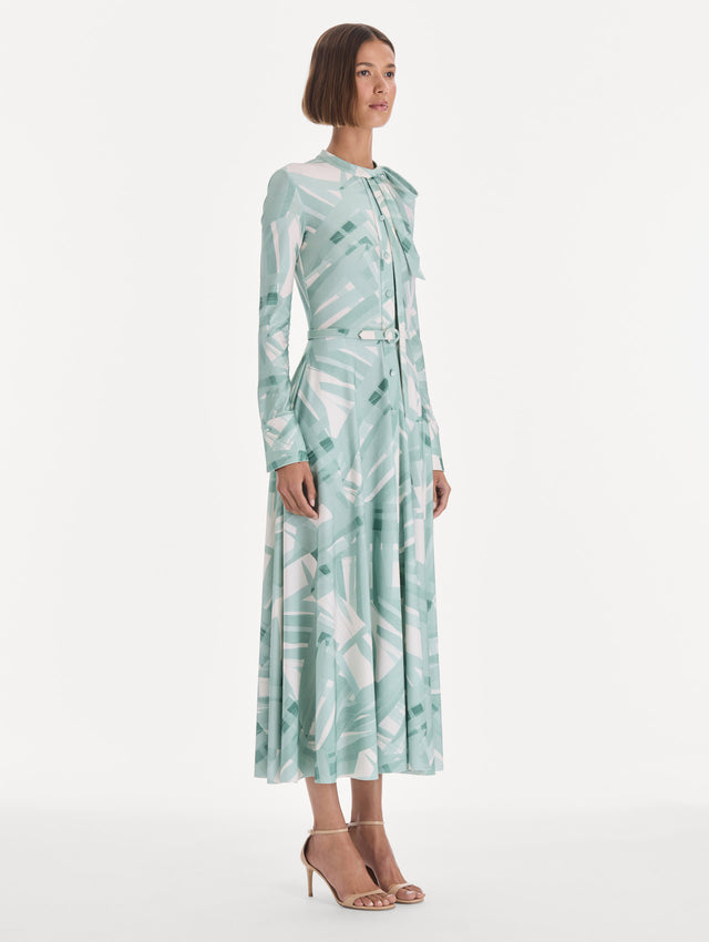 The model is wearing a long sleeve stripey plaid jersey day dress. Side view.